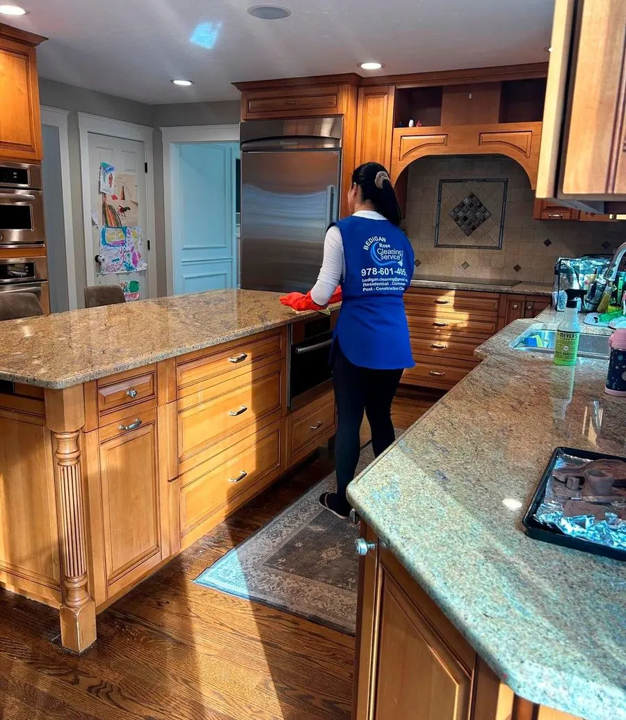 Bedigan cleaner wiping a granite kitchen island in a client home