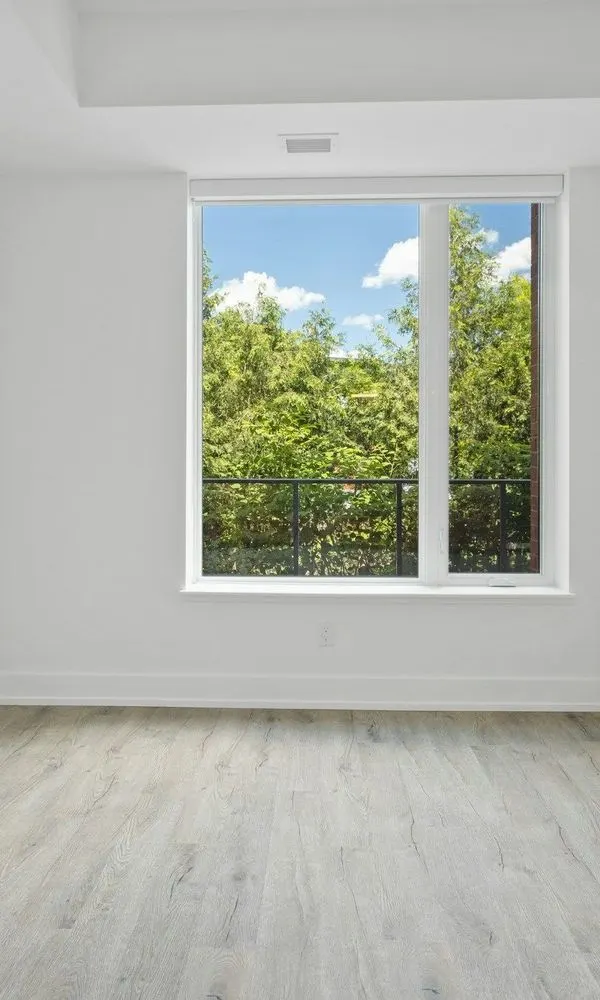 Bright empty room with a clean window and a new floor